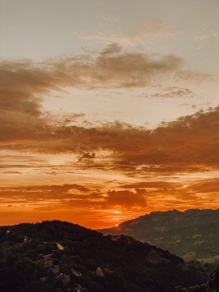 Captivating sunset sky over Sartène, Corse, creating a dramatic mountain silhouette.